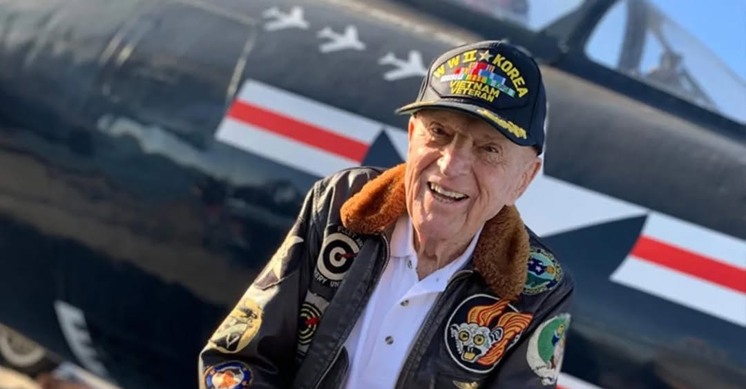 Captain Williams in his flight jacket in front of an F9F Panther