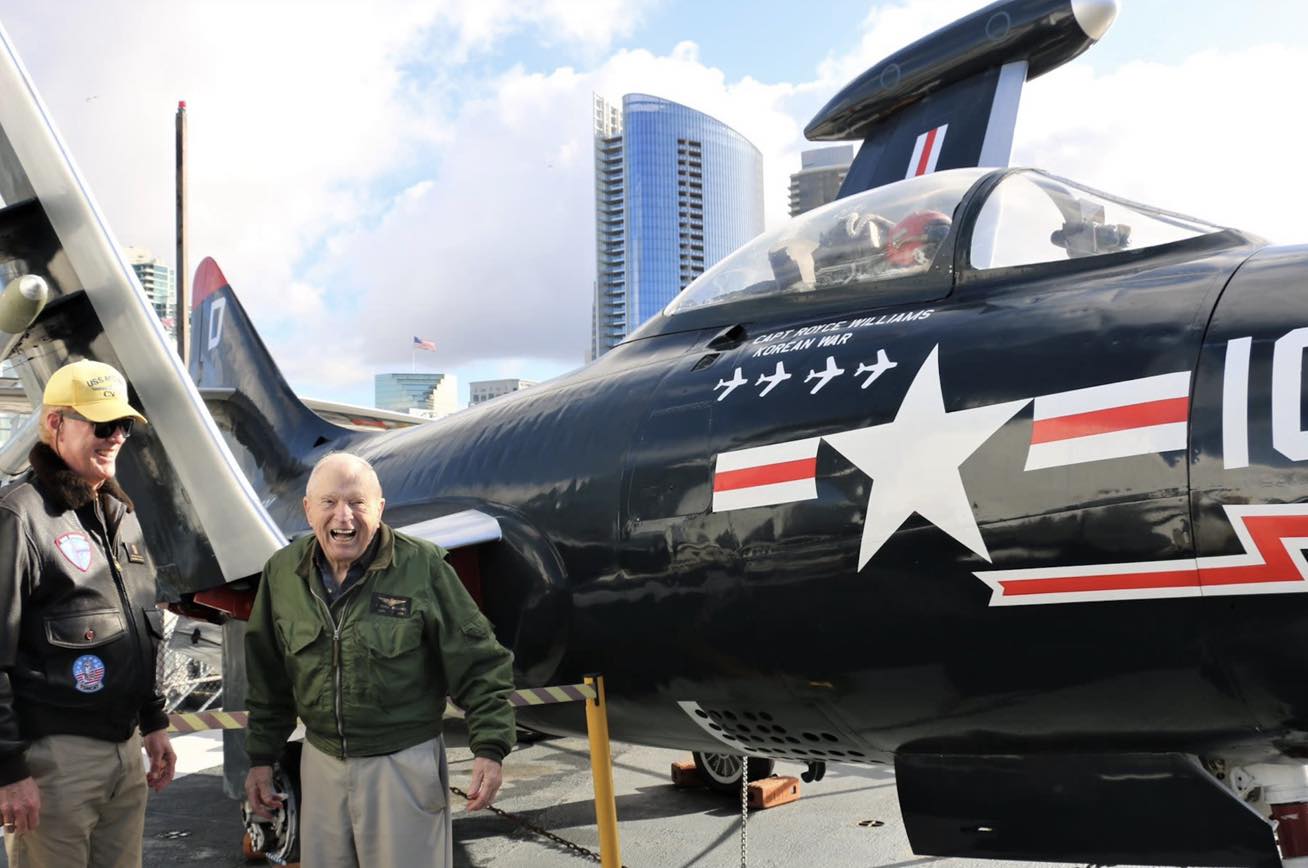 Captain Williams standing next to the F9F Panther on USS Midway
