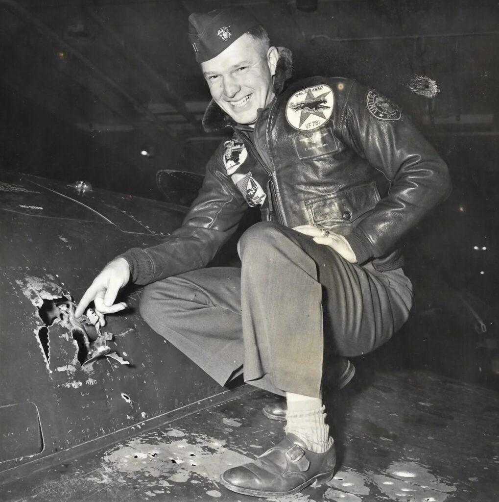 Lieutenant Williams pointing at battle damage on his F9F Panther